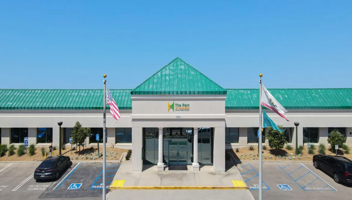A building with a green roof labeled “The Port” stands proudly, its two flagpoles and accessible parking out front reflecting the $3.935 Million State Grant for Port of Hueneme as California ramps up its Port Data Partnership Program.