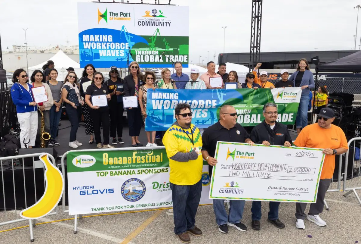 A group of people pose on a stage with banners and certificates, while four men in front hold an oversized check for $2,000,000 from the Oxnard Harbor District—highlighting the $3.935 Million State Grant for Port of Hueneme’s data partnership initiative.